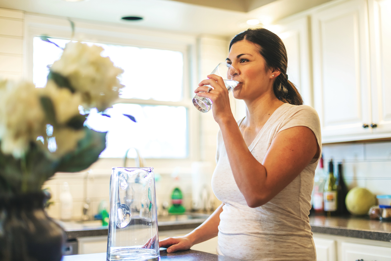 frau_trinkt_wasser_in_kuche_istock_gekauft.jpg